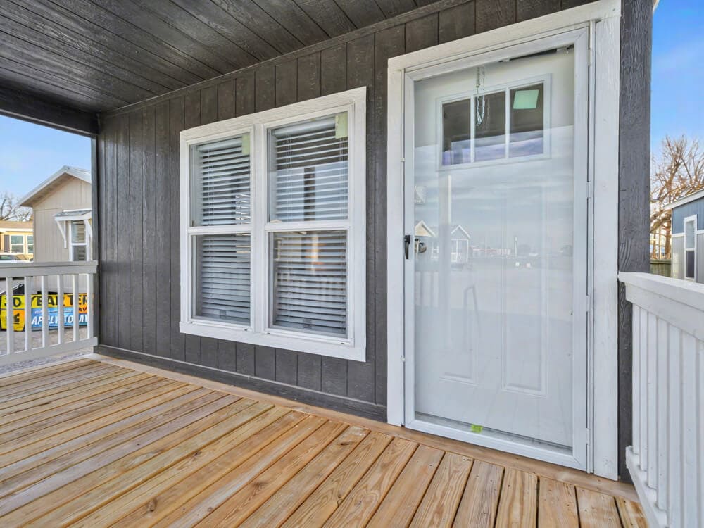 Covered front porch entry with white railing on the Bobby Jo manufactured home