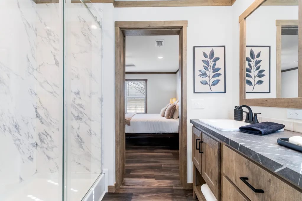 Walk-in shower and wood vanity in the Isabella Elite primary bathroom