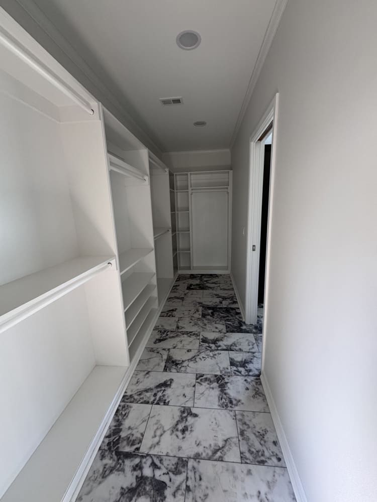 Oversized primary walk-in closet with built-in shelving in The Shoreline 4-bedroom manufactured home