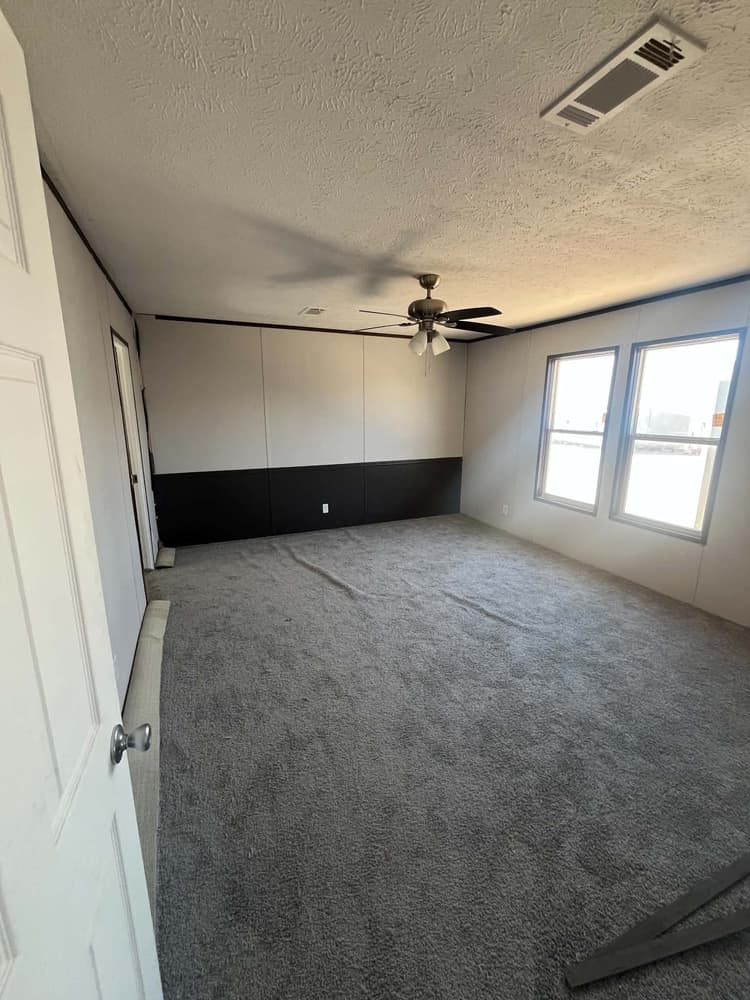 Carpeted bedroom with ceiling fan and paired windows in Cavco 28x72 home #3254 at New Start Homes in El Paso, TX