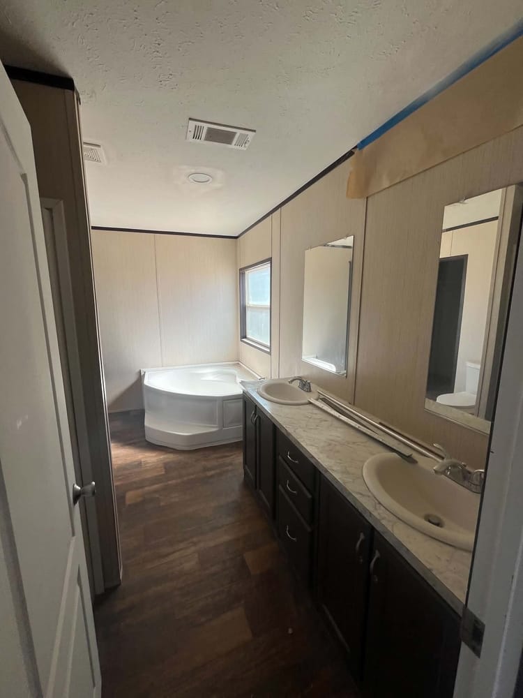 Double vanity beside a corner bathtub in Cavco 28x72 home #3254 at New Start Homes in El Paso, TX