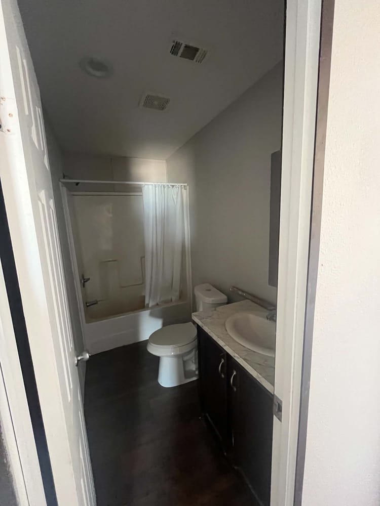 Bathroom with tub-shower combination, toilet and vanity in Cavco 28x72 home #3254 at New Start Homes in El Paso, TX