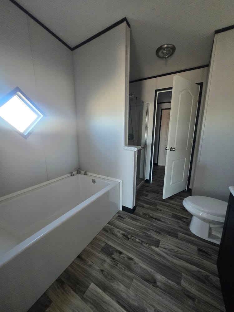 Bathtub beneath a diamond-shaped window in Legacy Housing H-3248-32A 32x48 home #5868 at New Start Homes in El Paso, TX