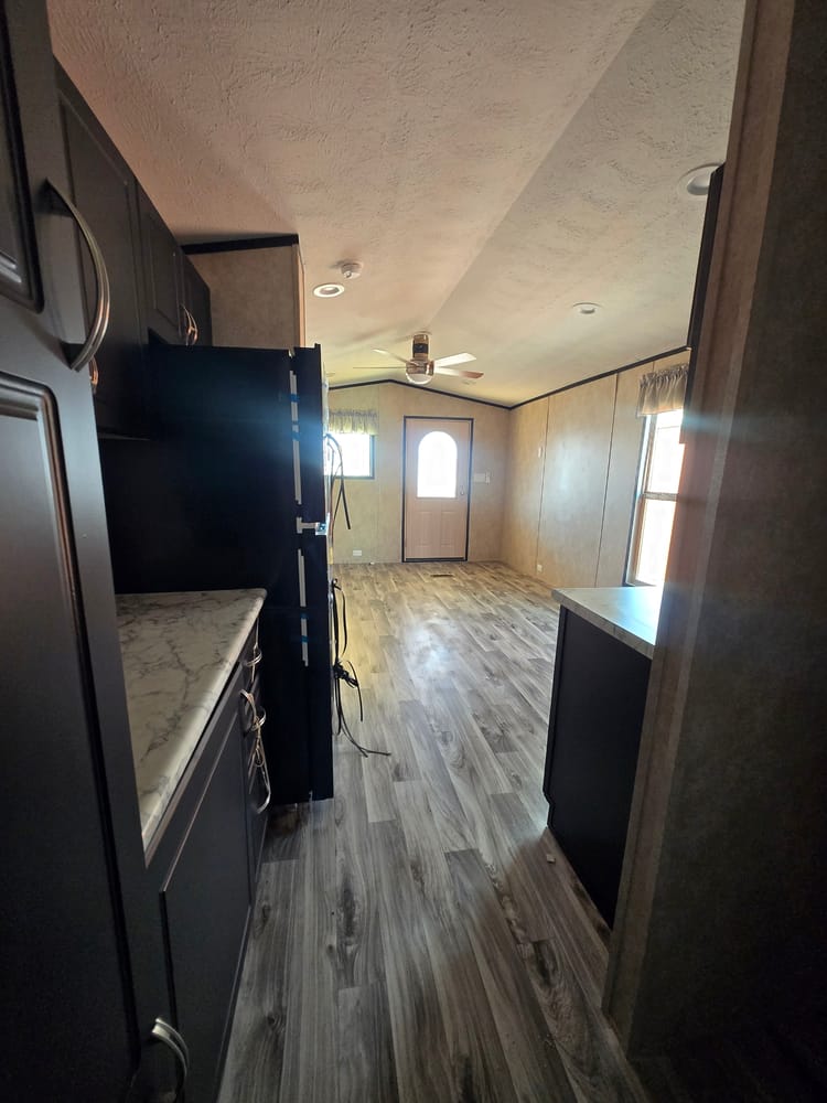 Galley kitchen looking toward the living area in Legacy Housing S-1236-11FLA 12x36 home #5915 at New Start Homes in El Paso, TX