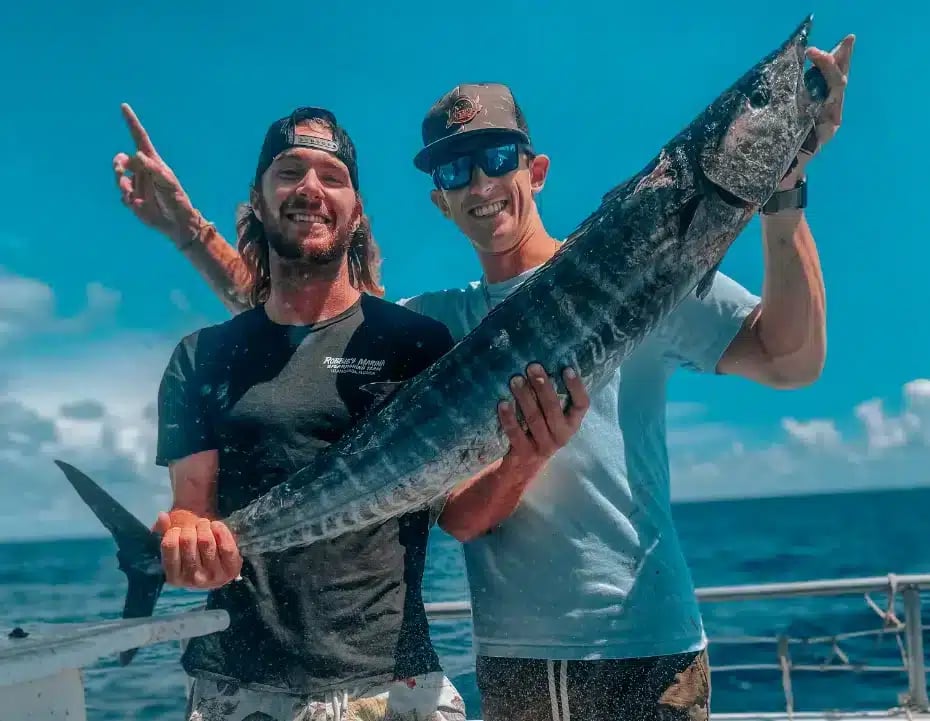 Two anglers holding their catch on a Florida Keys party boat
