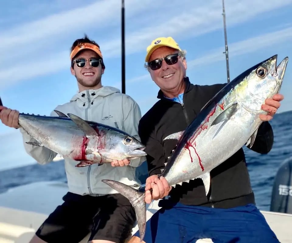 Two anglers holding tuna aboard a Go Time charter offshore of Islamorada