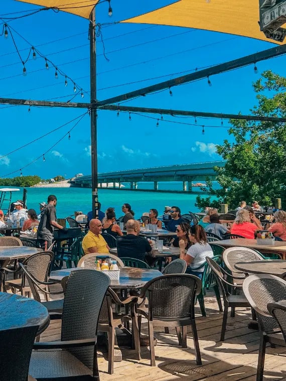 People dining at Hungry Tarpon Restaurant by the ocean