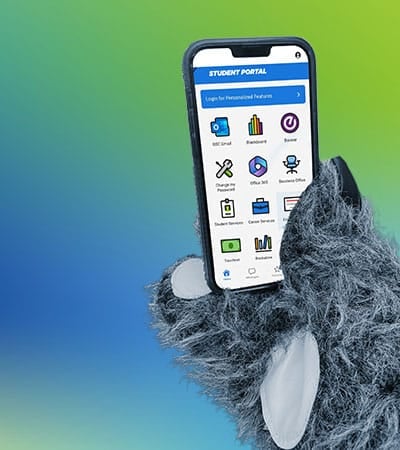 A furry mascot hand holds a smartphone displaying a student portal, promoting the convenience of downloading the mobile app for easy access to campus resources.
