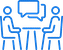 Two outlined figures sitting at a table with a speech bubble above, indicating a conversation or discussion.