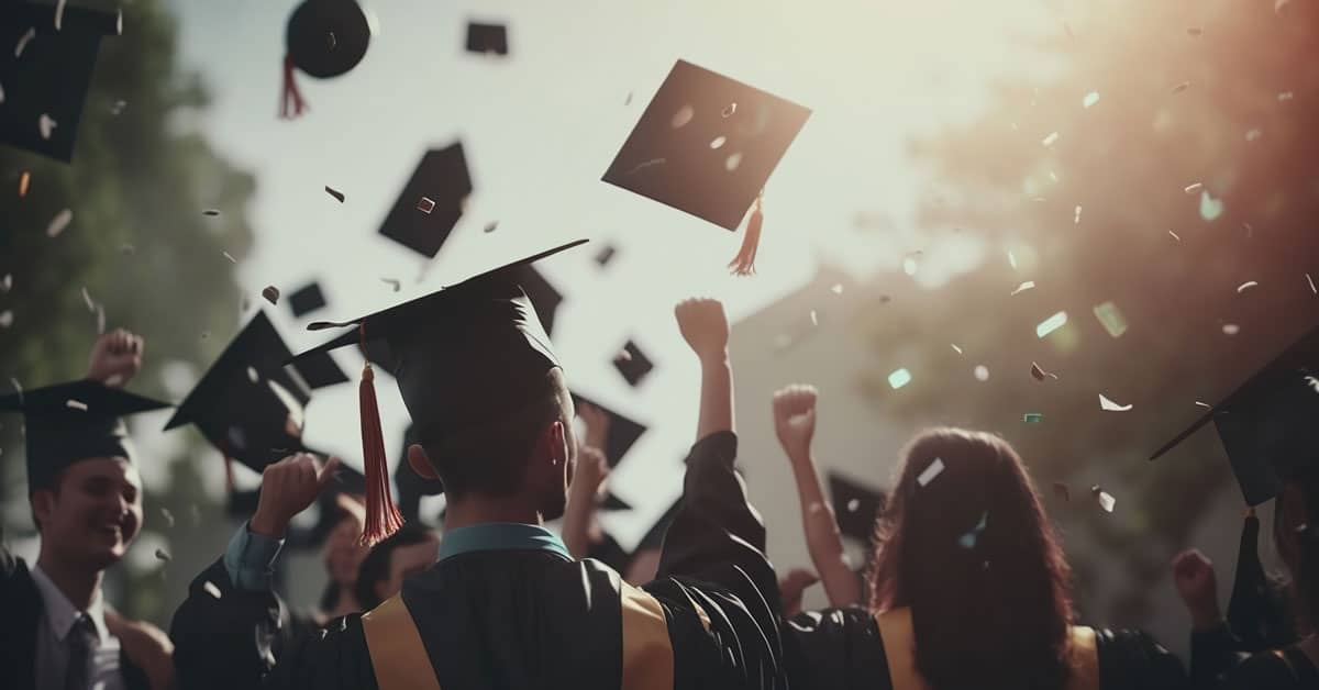 A group of graduates in caps and gowns celebrate outdoors, throwing their caps into the air with hands raised, surrounded by sunlight and confetti, capturing the joyful spirit of an Online Commencement Ceremony.
