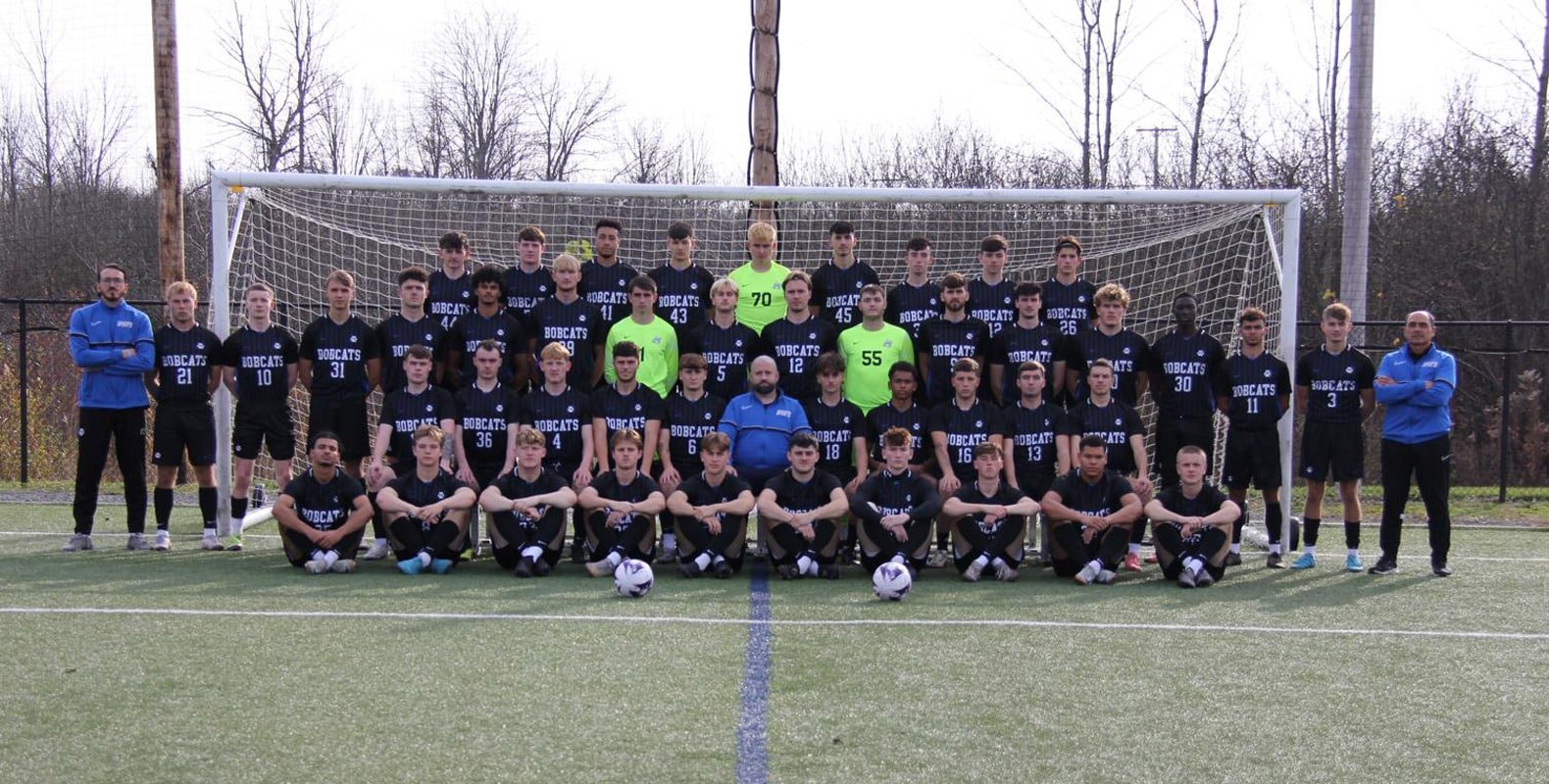 The Bryant & Stratton men's soccer team posing together on a field in front of a goal, wearing 'Bobcats' jerseys.