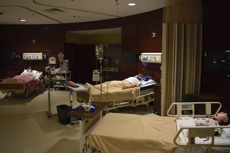 Hospital room with three beds, medical equipment, and mannequins simulating patients in various medical scenarios.