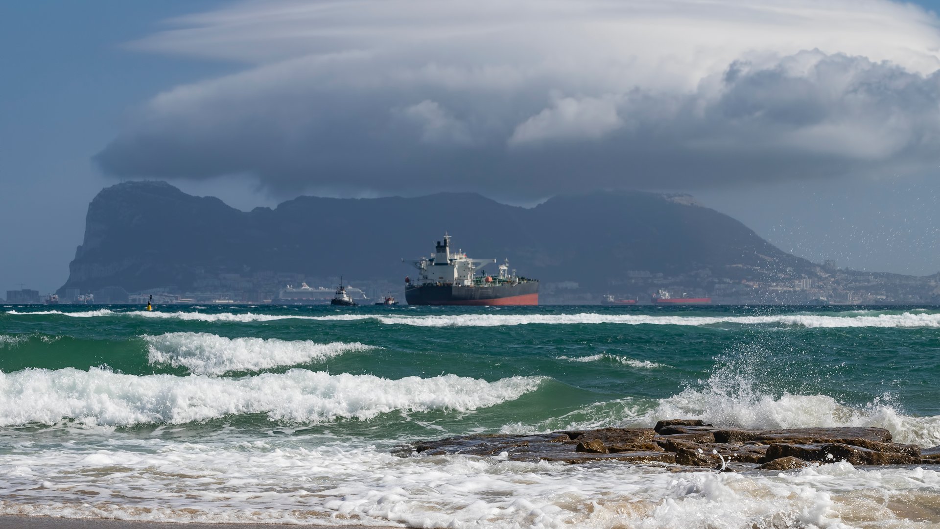Palmones Kitesurfing in Spain view to the gusty sea with a fright ship and impressive mountain and clouds in the background