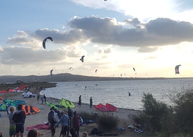 Punta Trettu Kitesurfing in Sardinia view close from the beach with a lot of kitesurfers preparing the kite or already about 20 on the water