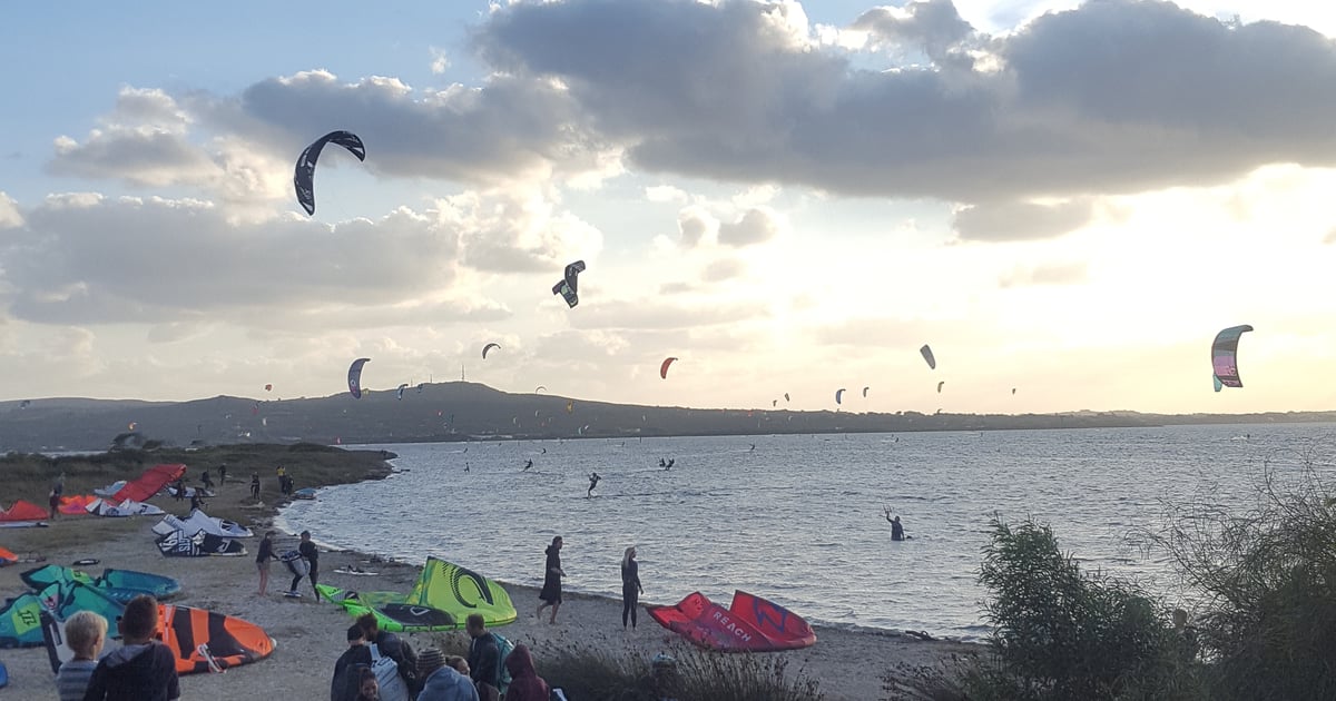 Punta Trettu Kitesurfing in Sardinia view close from the beach with a lot of kitesurfers preparing the kite or already about 20 on the water