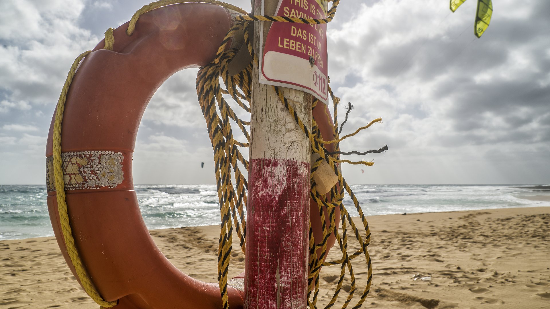 Flag Beach Kitesurfing in Fuerteventura one yellow kite at the sky and a rescue ring in front