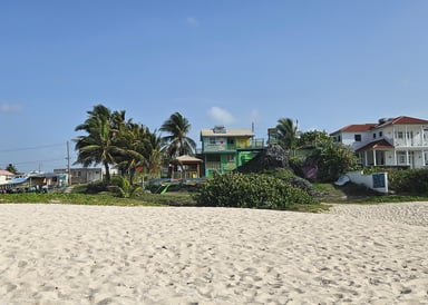 View white sandy beach at silver sand and rocks barbados with colorful house in the background