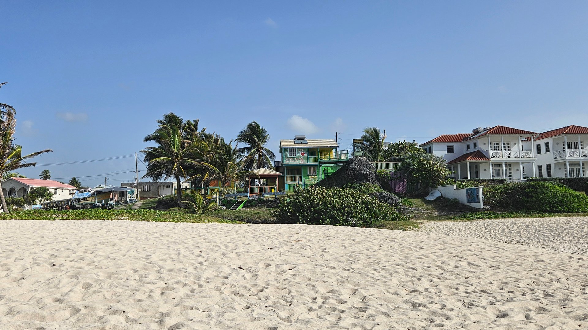 View white sandy beach at silver sand and rocks barbados with colorful house in the background