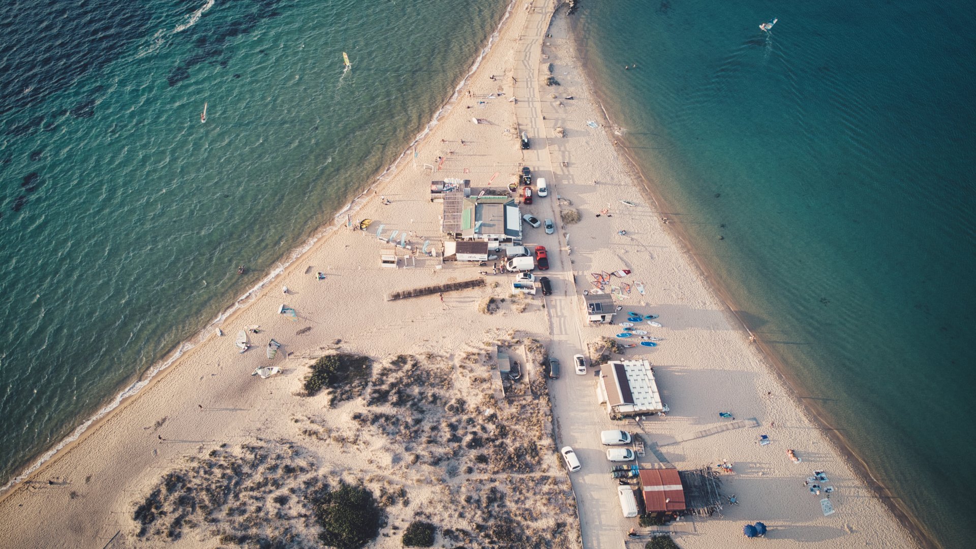 Porto Pollo Kiteboarding in Sardinia drone view to the surf camp houses on the sandy triangle beach