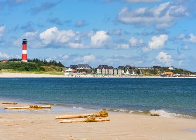 Hoernum Kitesurfing in Sylt with houses, beach and lighttower in the background