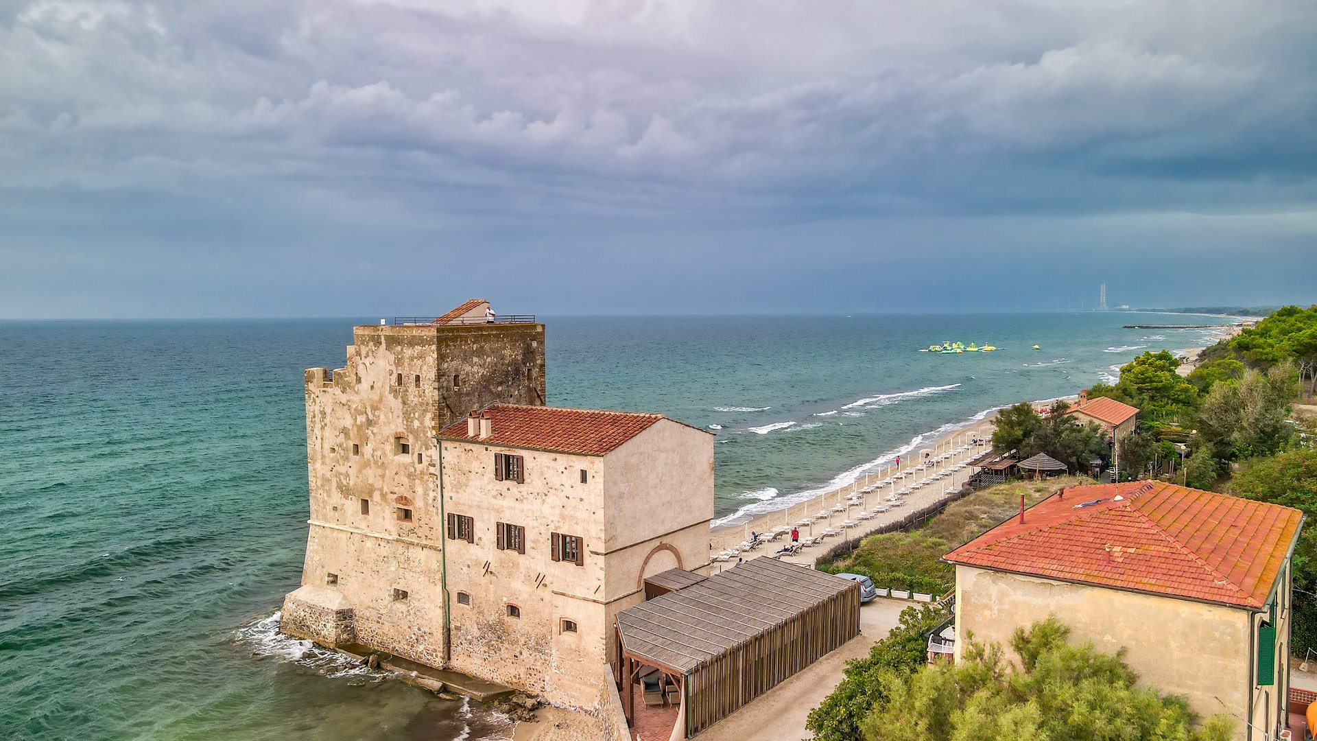 Follonica Kiteboarding in Italy image closeup of the small caslte on a cloudy day right at the beach with green water