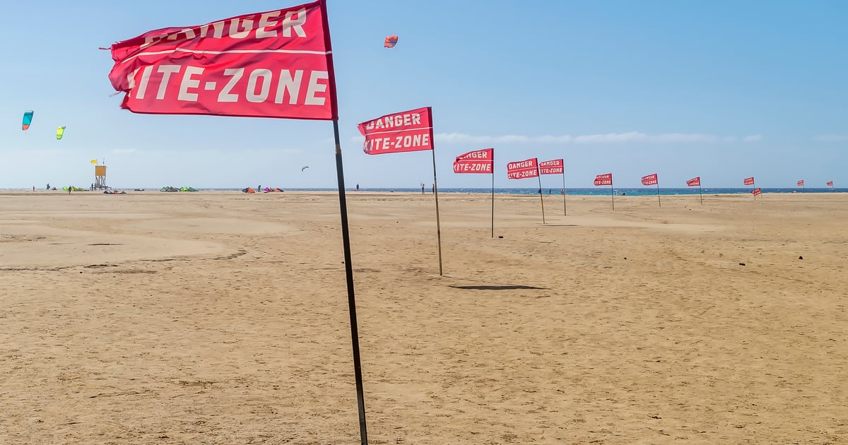 Flag Beach Kitebsurfing in Fuerteventura white sand and turquoise water and a picturesque hill in the background looking like an island