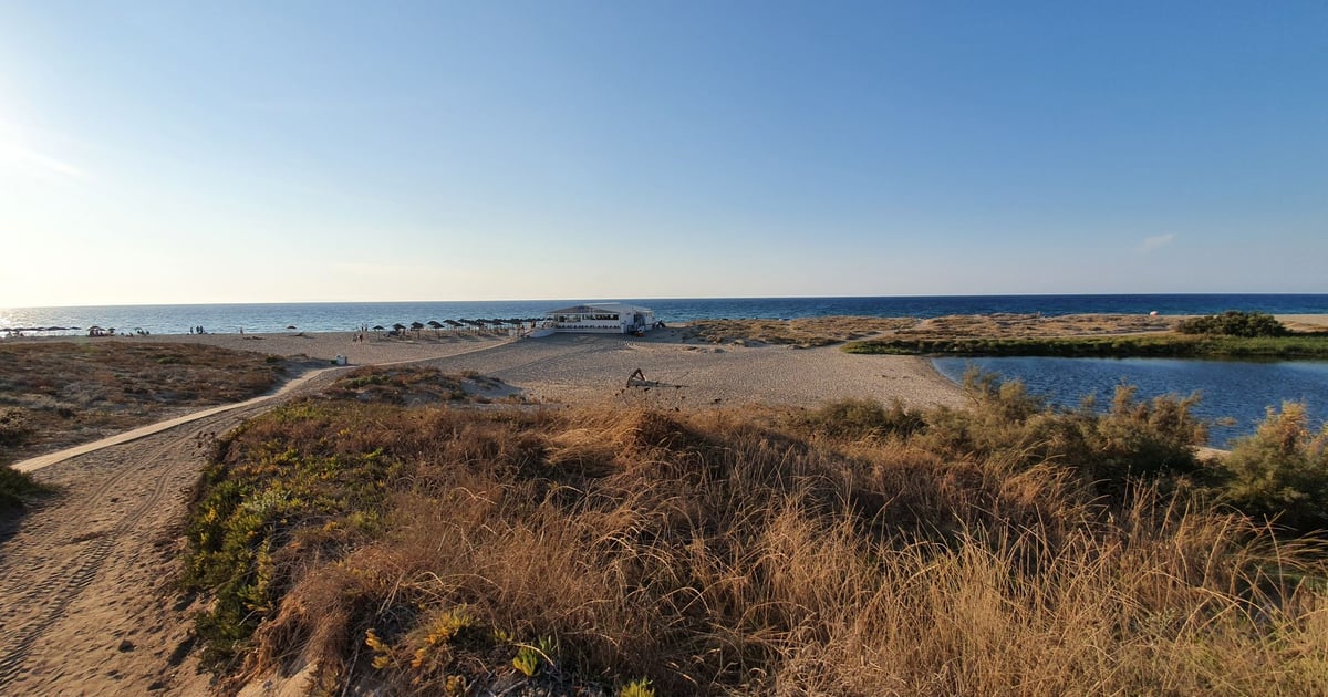 Valledoria Kiteboarding in Sardinia Italy view from countryside from far to the beach with sun umbrellas and blue sky