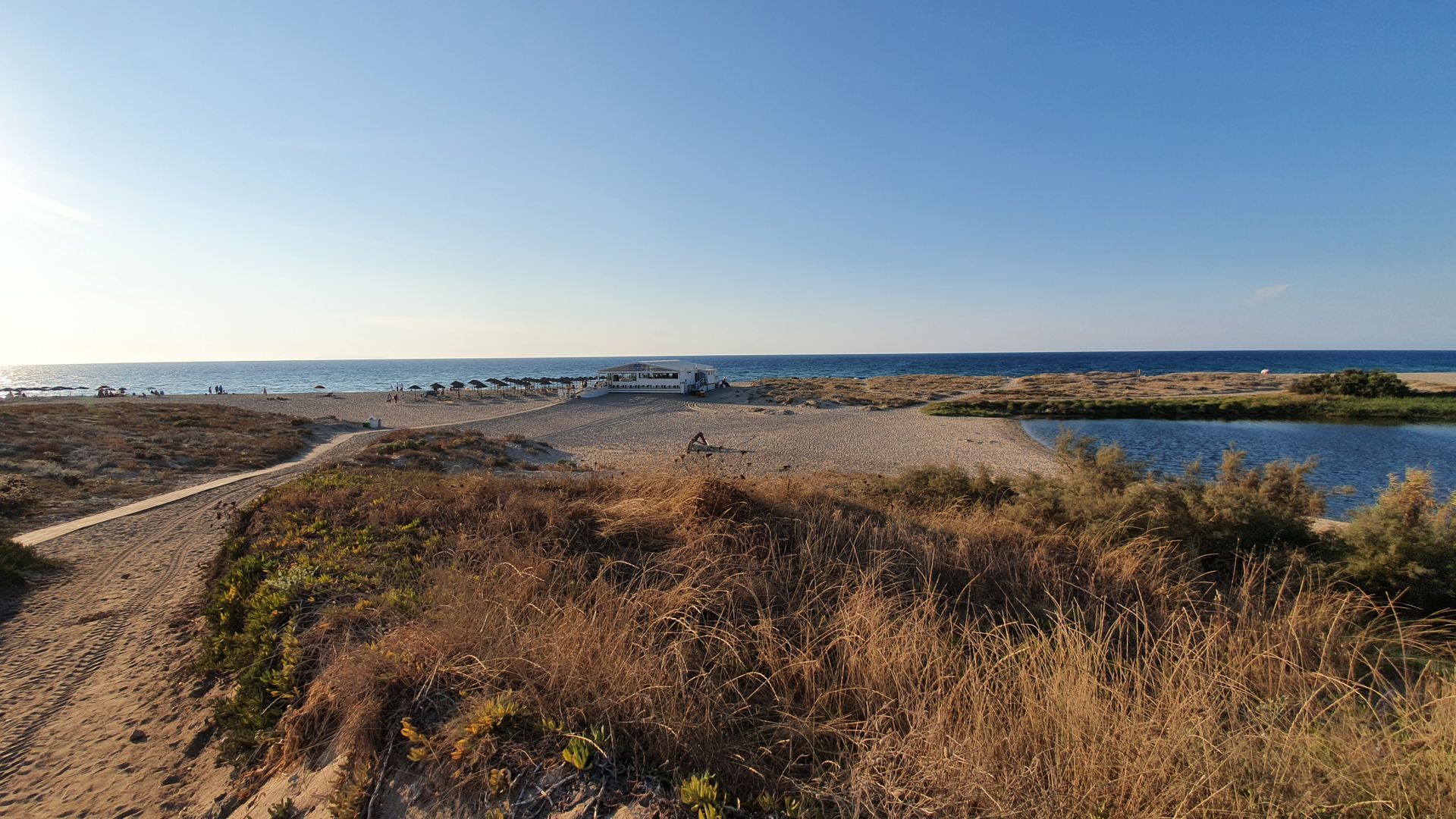 Valledoria Kiteboarding in Sardinia Italy view from countryside from far to the beach with sun umbrellas and blue sky