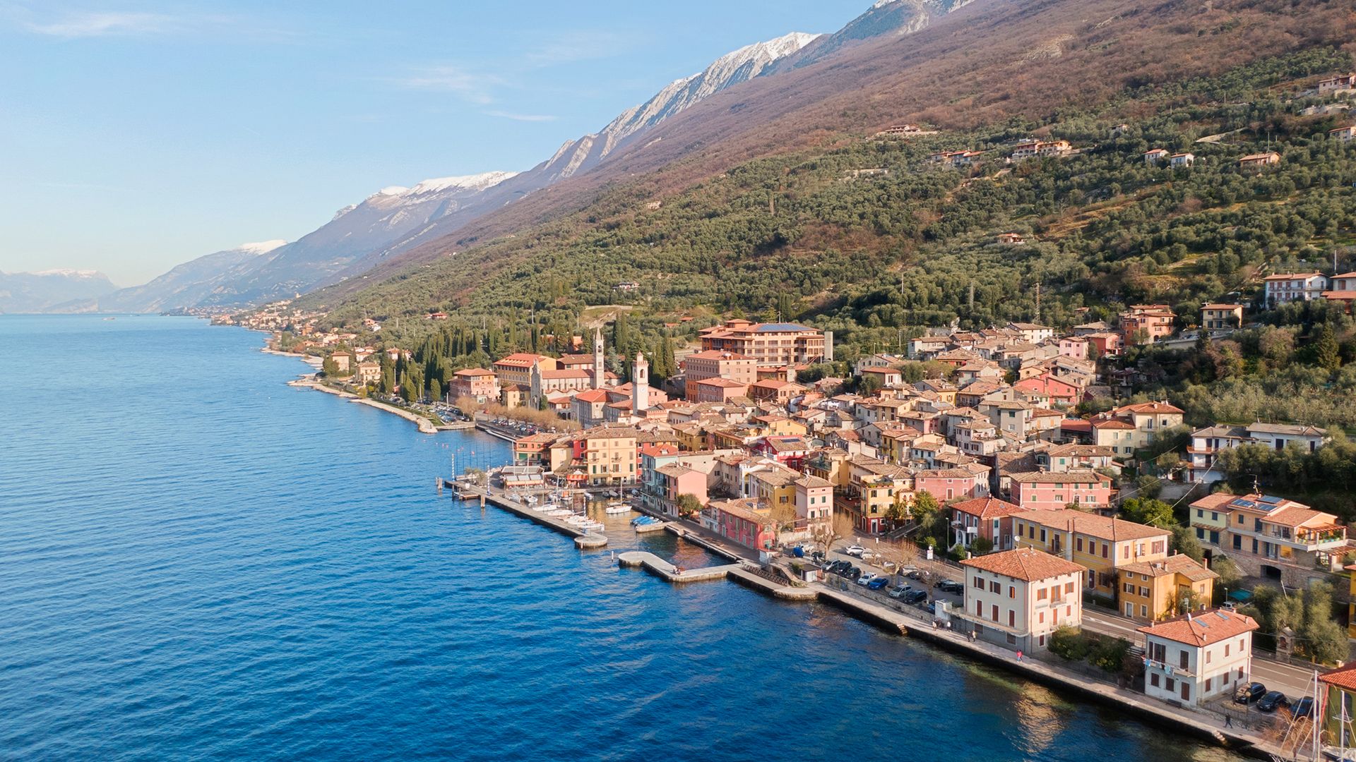 Brenzone Kitesurfing in Lake Garda aerial view from the lake with the small town of Brenzone and Mountains in the background with very blue water