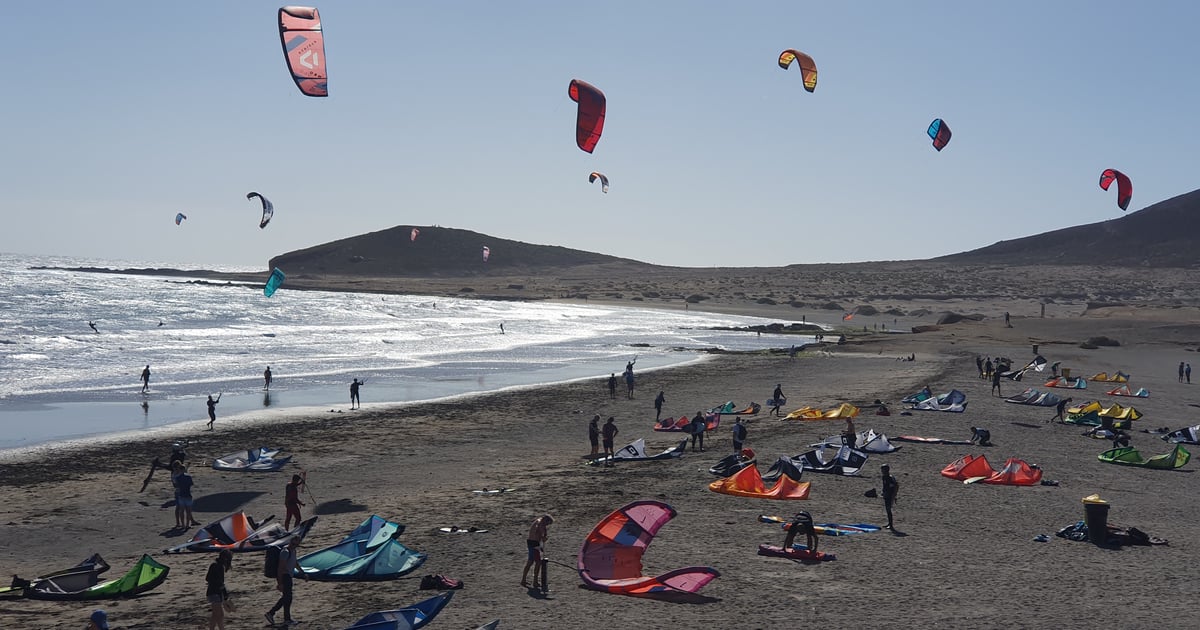 Playa El Medano Kiteboarding in Tenerife view into the sun with wind- and kitesurfers on gusty sea