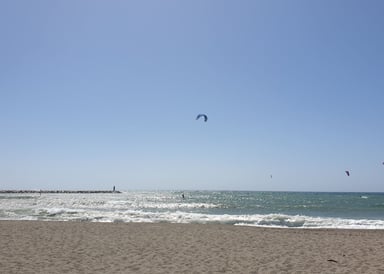Empuriabrava Kiteboarding in  Spain beach view with a few kitesurfers on the long beach