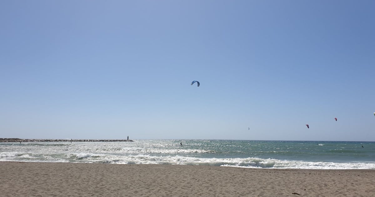 Empuriabrava Kiteboarding in  Spain beach view with a few kitesurfers on the long beach