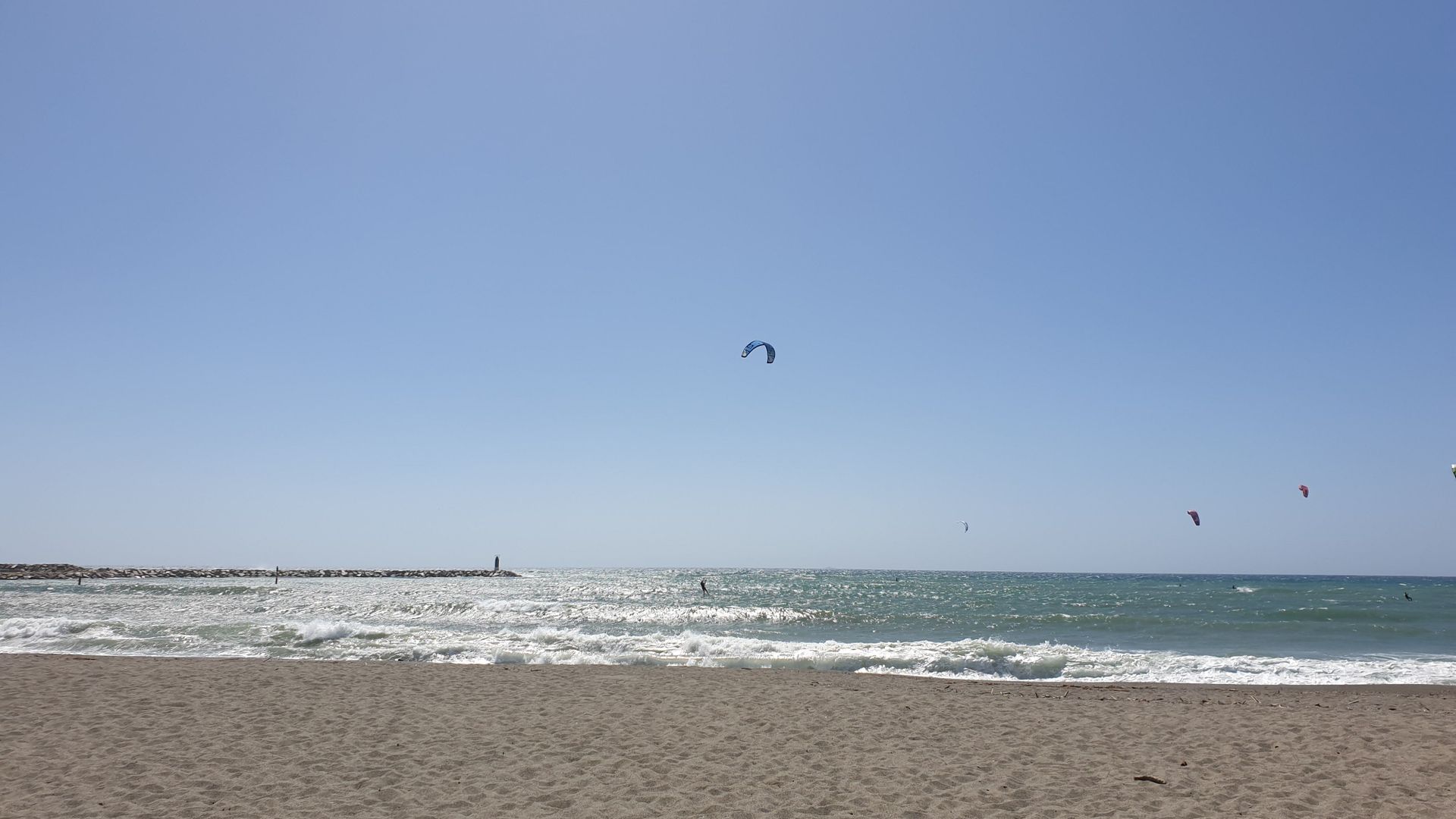 Empuriabrava Kiteboarding in  Spain beach view with a few kitesurfers on the long beach