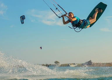 Girl jumping high in Kitesurfing in Djerba Lagoon