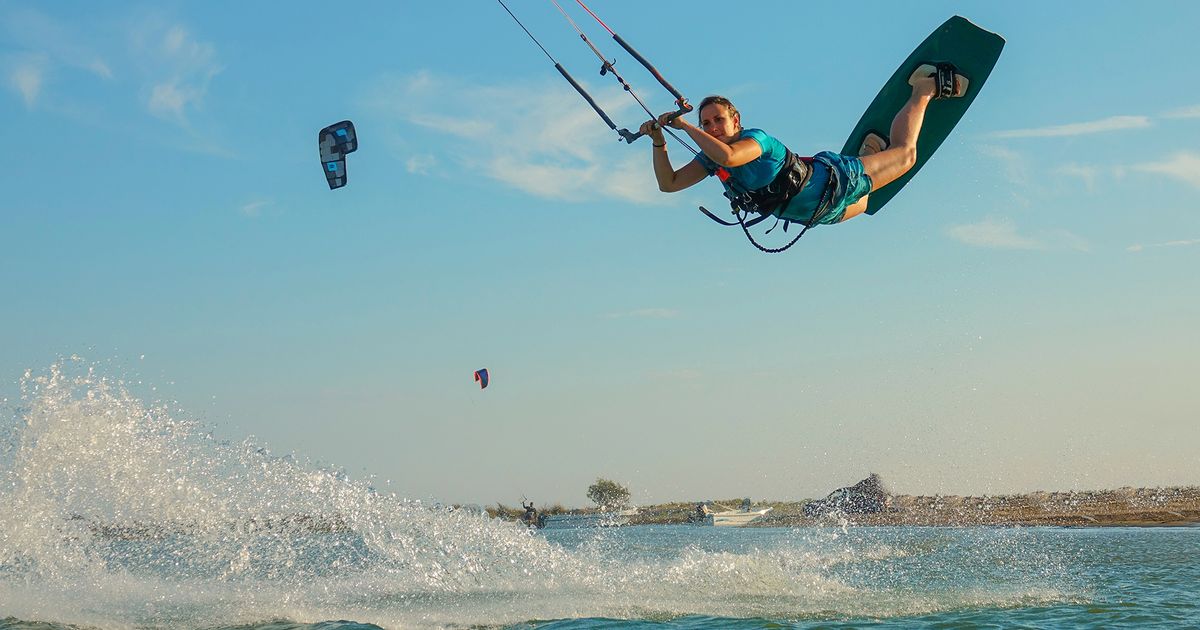 Girl jumping high in Kitesurfing in Djerba Lagoon