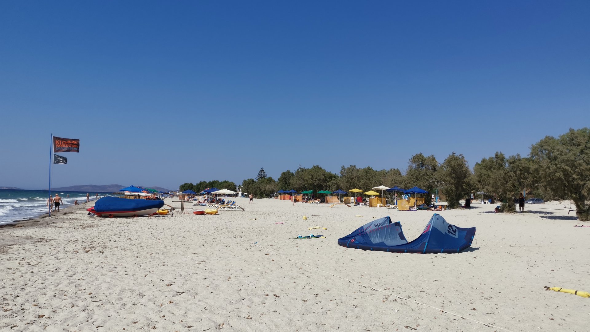 Mastichari Bach Kiteboarding in Kos view from the beach wiht bright sand and some kites laying in the sand because of low wind.