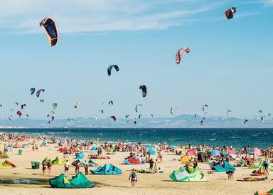 Los Lances Kitesurfing in Cadiz beach very crowded with kitesurfers all over the beach and on the sea with hundreds of kites up in the sky