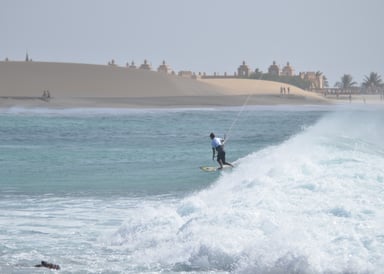 Wave Sufer riding a white water wave at Kitesurfspot Ponta Preta