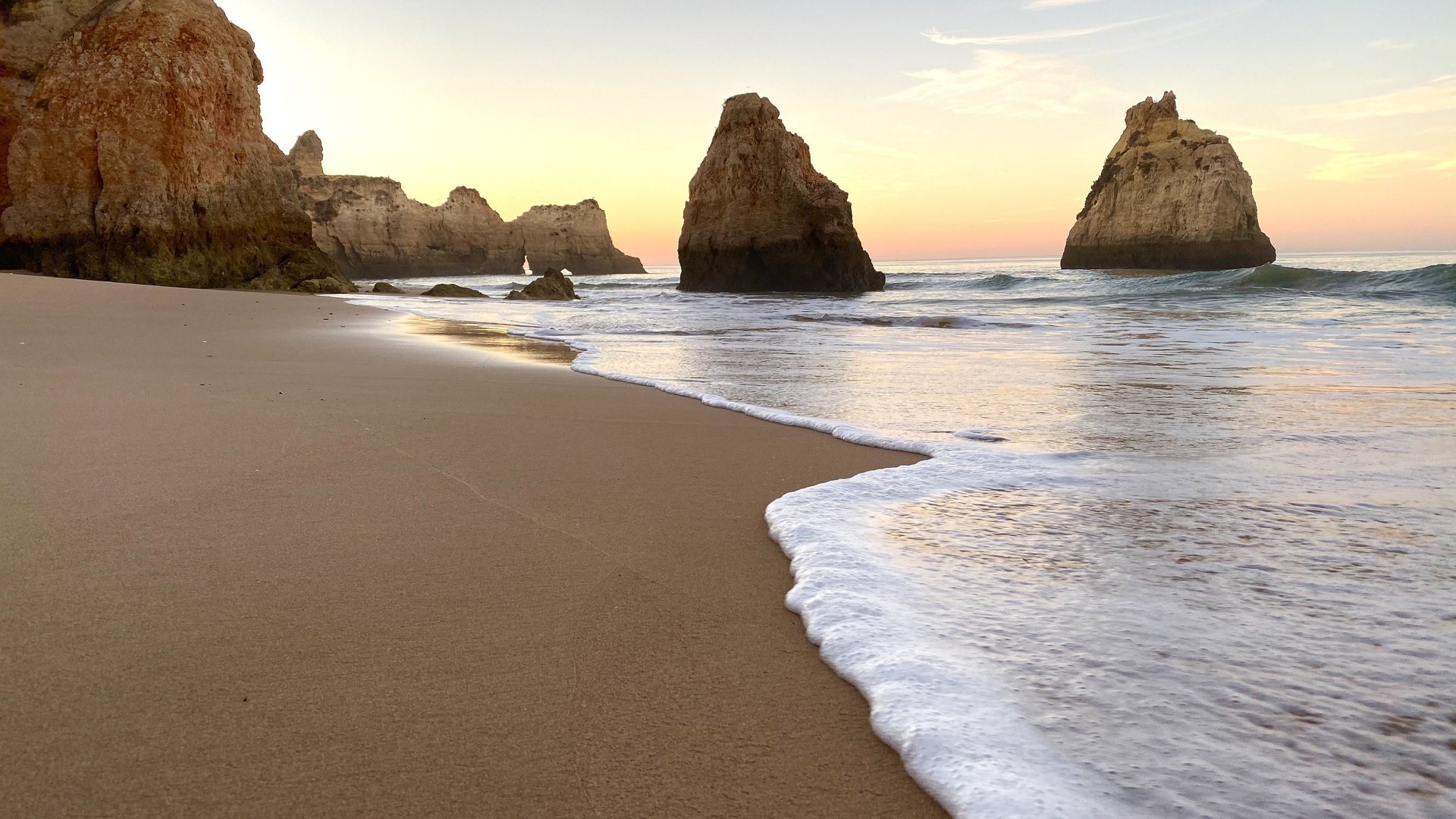 beatufiful view of the beach against scenic sunset in alvor