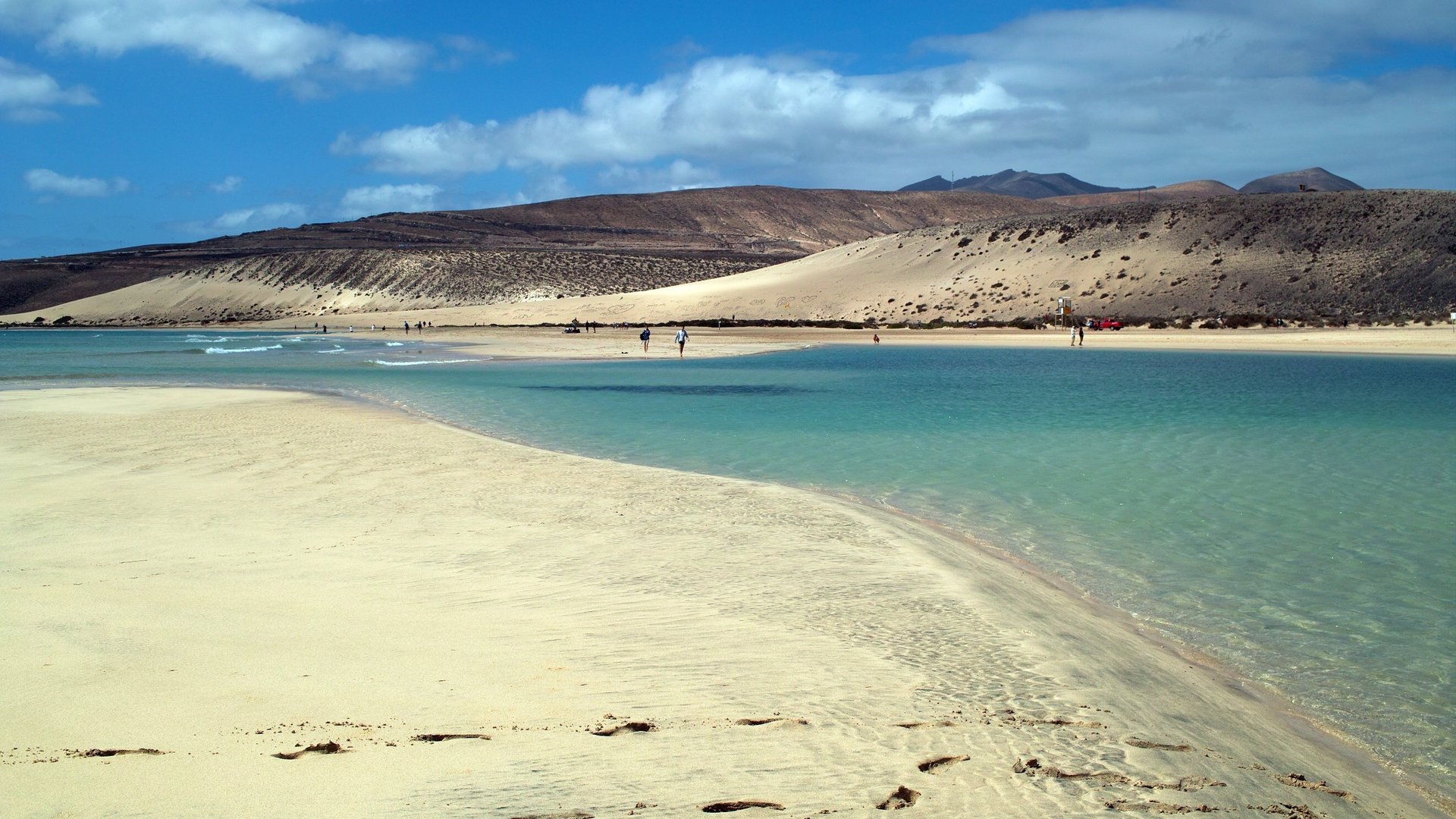 Jandia Beach Kitesurfing in Fuerteventura image of beautiful blue and green water ans small flat stony hills in the background