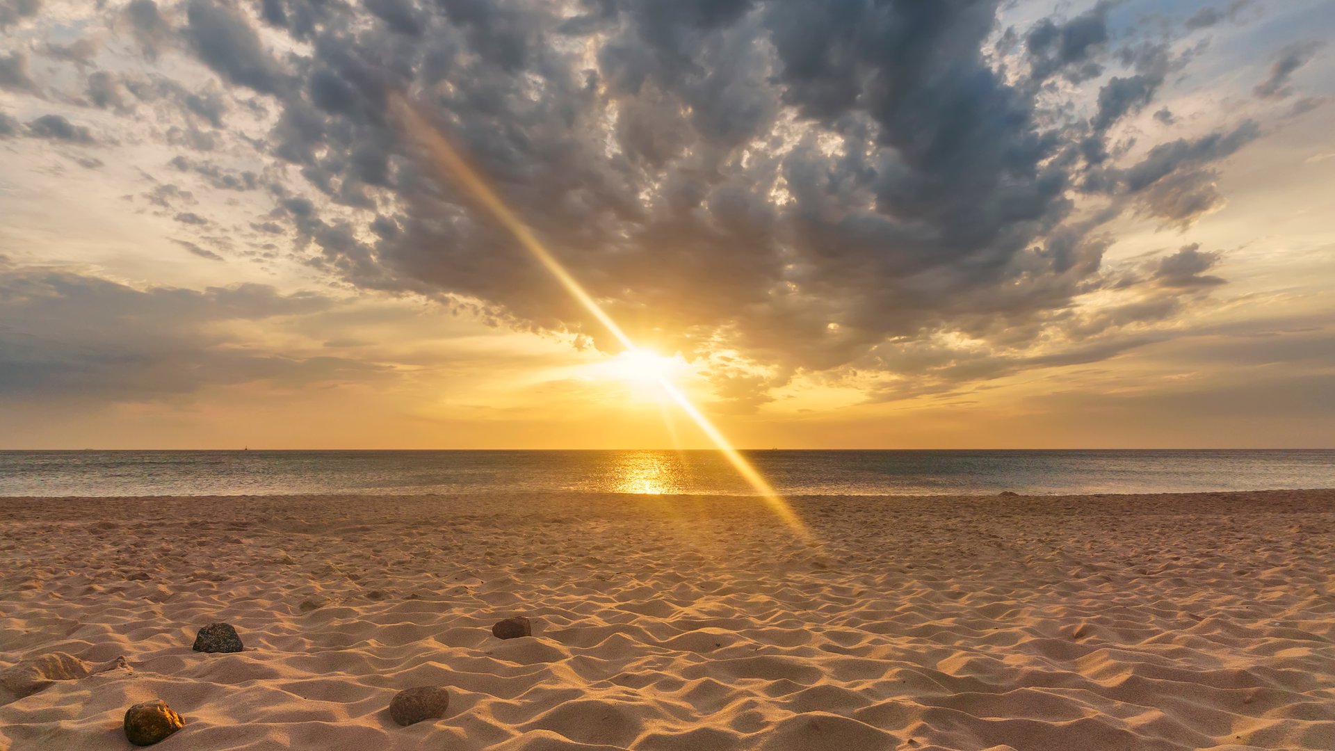 Kampen Kitesurfing Sylt beach with yellow-orange sun shing through the clouds