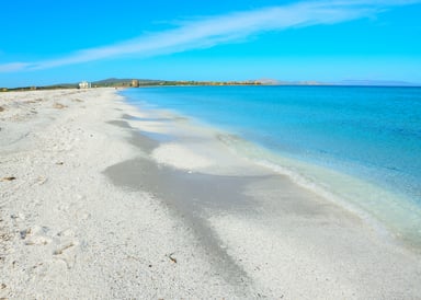 Le Saline Kiteboarding Spot in Italy white sand on the beach without any people on it and very bright blue water and sky