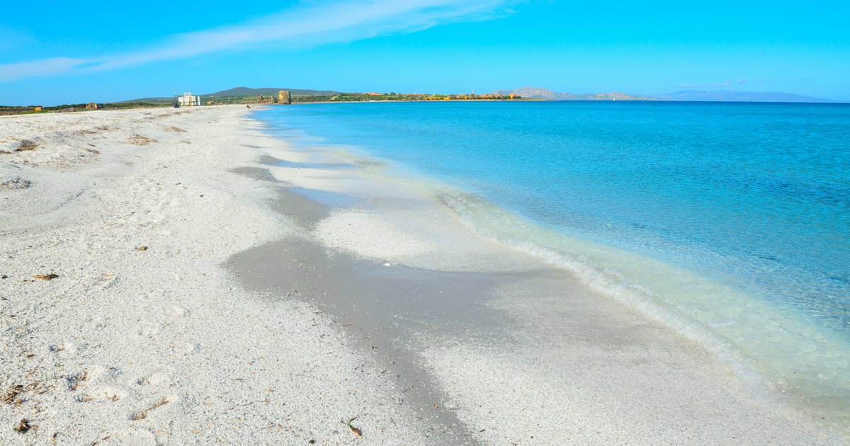 Le Saline Kitesurfing in Sardinia view from the white sandy beach with a signpost written “Kitebar” on it