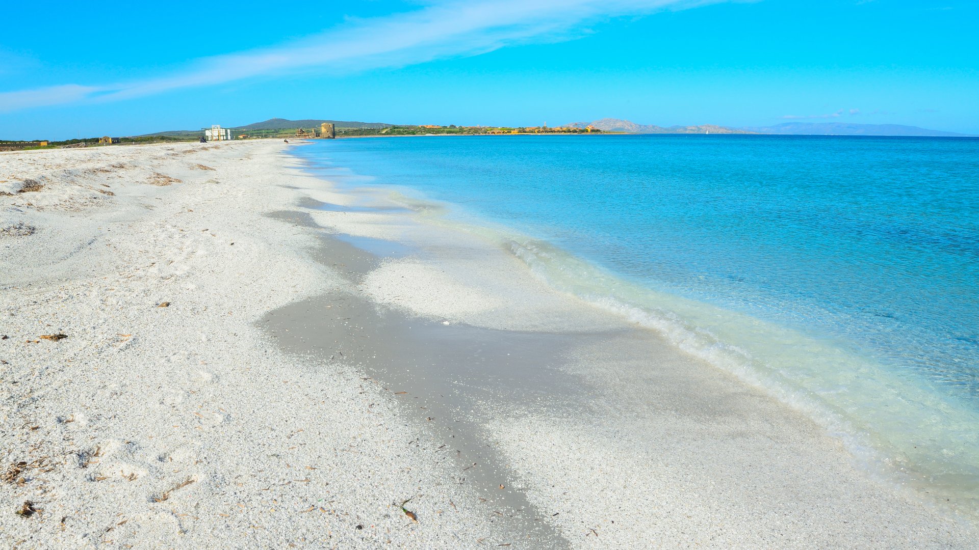 Le Saline Kiteboarding Spot in Italy white sand on the beach without any people on it and very bright blue water and sky