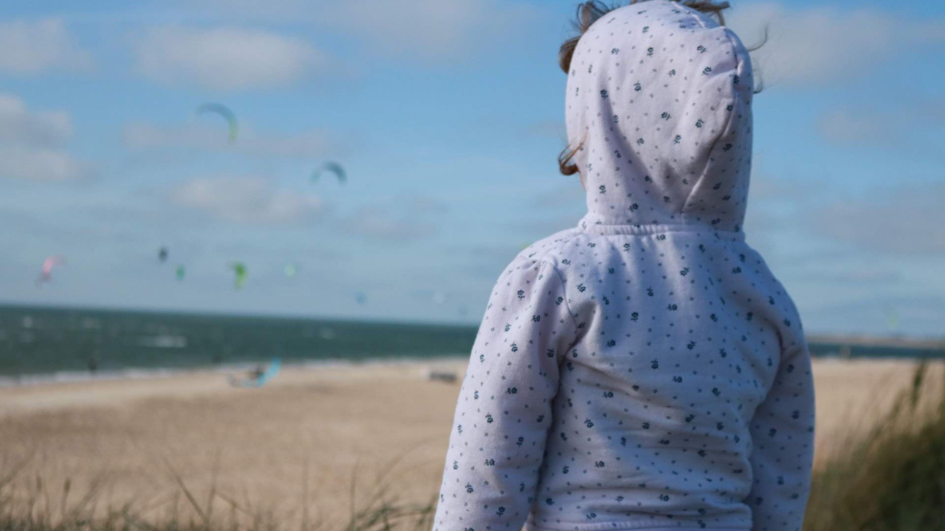 Kid watching kitesurfers in Brouwersdam kite beach 