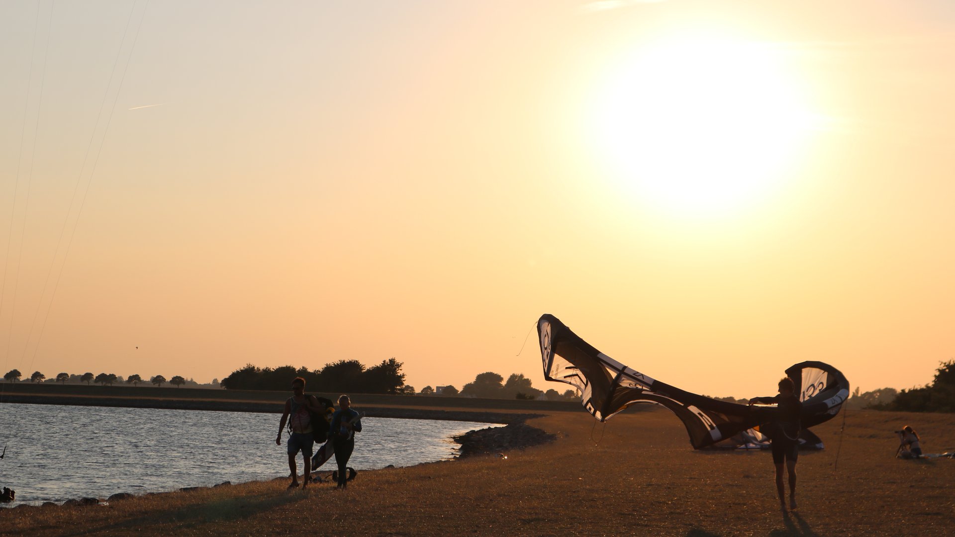 Gollendorf Kitesurfer in Germany lifting her Kite at the beach at golden light daytime