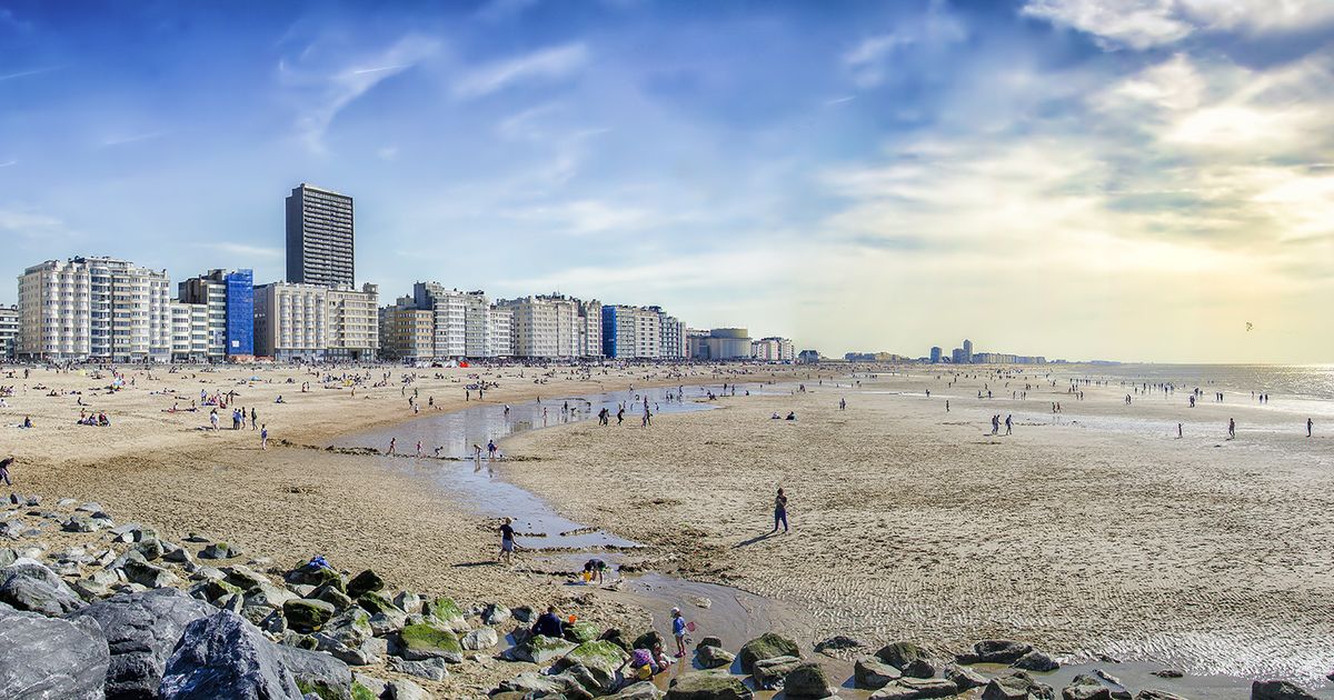 Oostende Kitsurfing Belgium Beach with people walking around in the sun with high buildings in the background