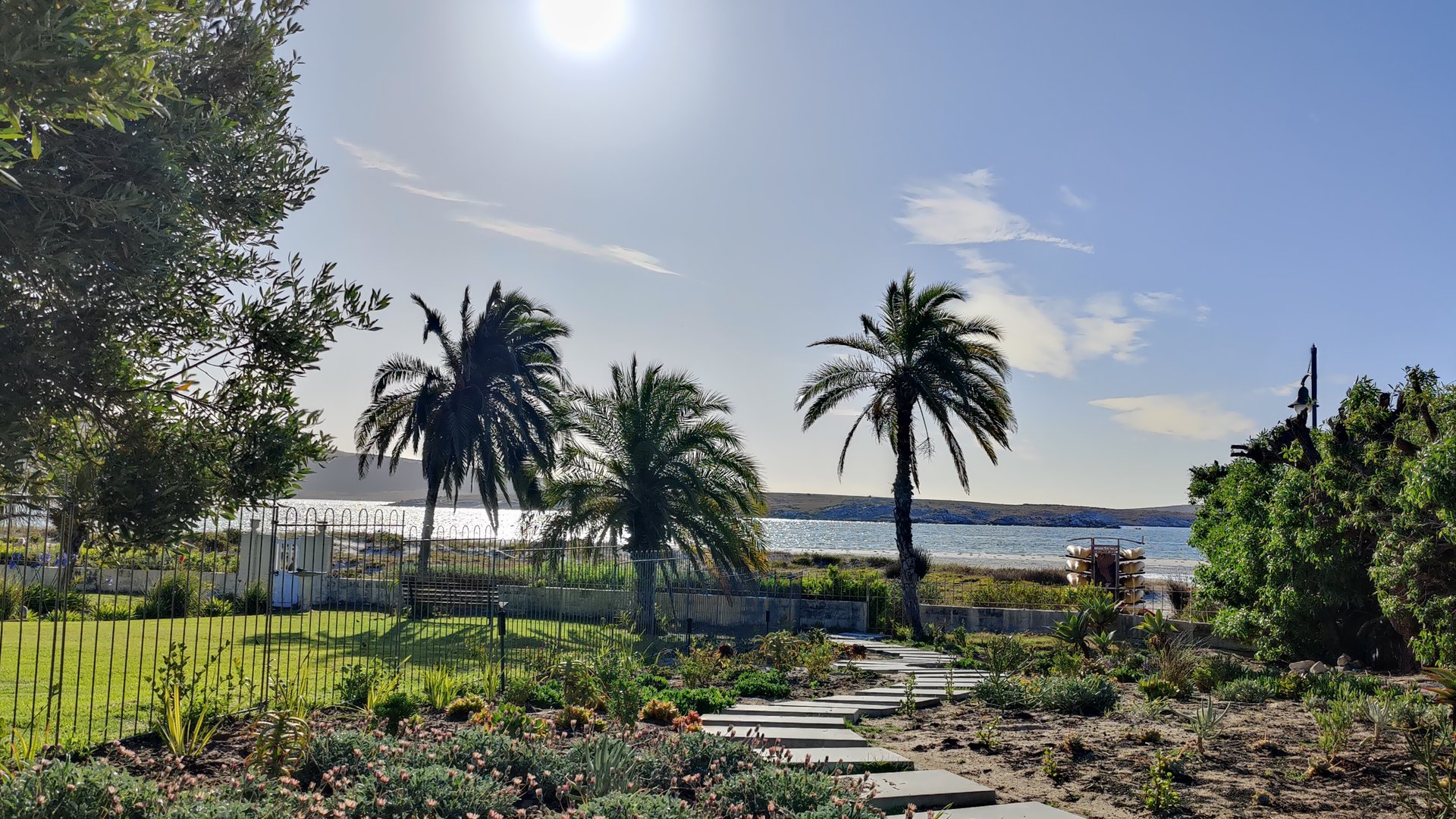 View from private appartment to palm tree garden with Langebaan laggoon in the background