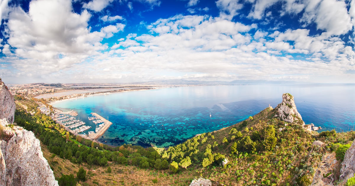 La Maddalena Spiaggia Kitesurfing in Sardinia view from the green mountain to the harbour and beachline on a cloudy day