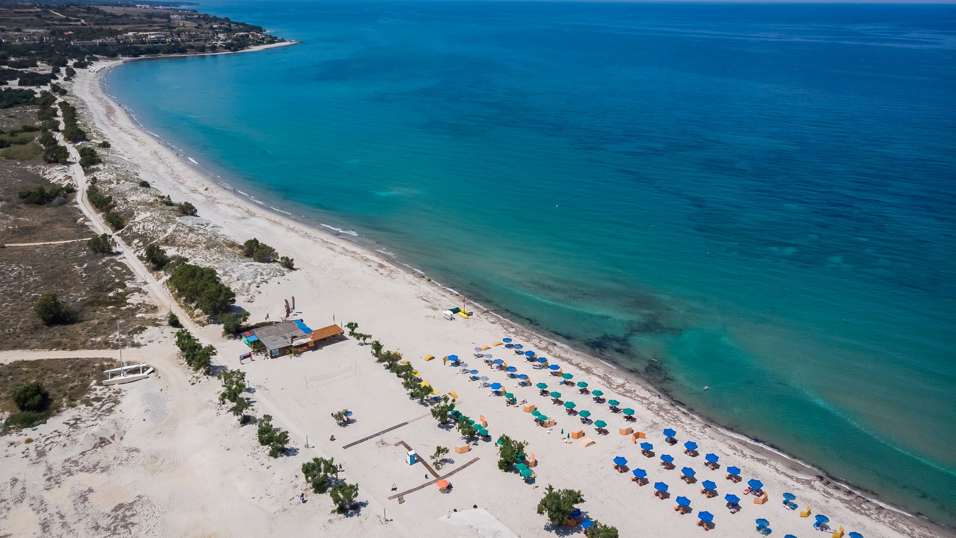 Marmari Beach Kitesurfing in Kos view from above along the large sandy beach with lounge chairs and the turqouise ocean